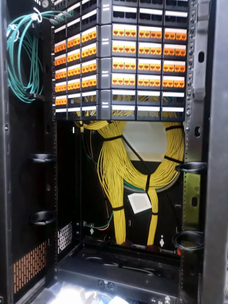 Patch panels with orange jacks above neatly looped cable