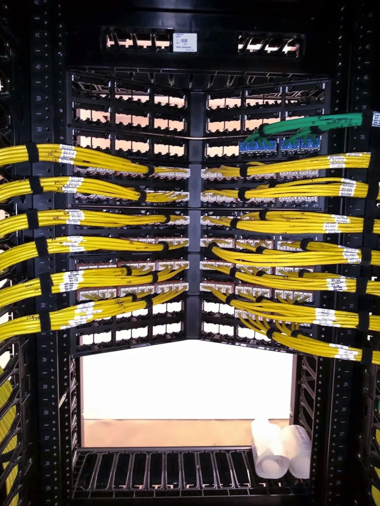 Bundled and labeled yellow patch cables terminated on a rack
