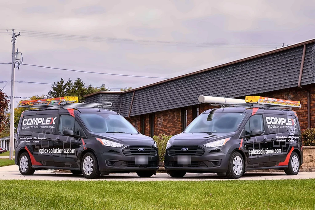Two Complex Security Solutions service vans parked outside the office