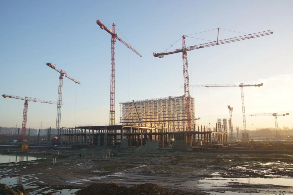 Commercial construction site with tower cranes at sunset