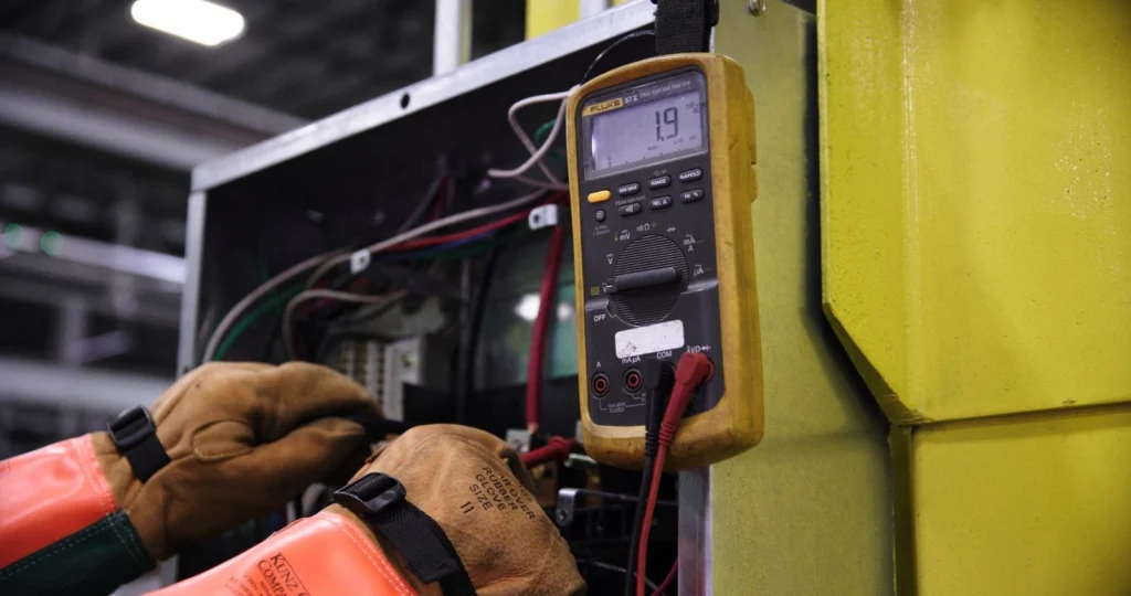 Technician testing control panel wiring with a multimeter